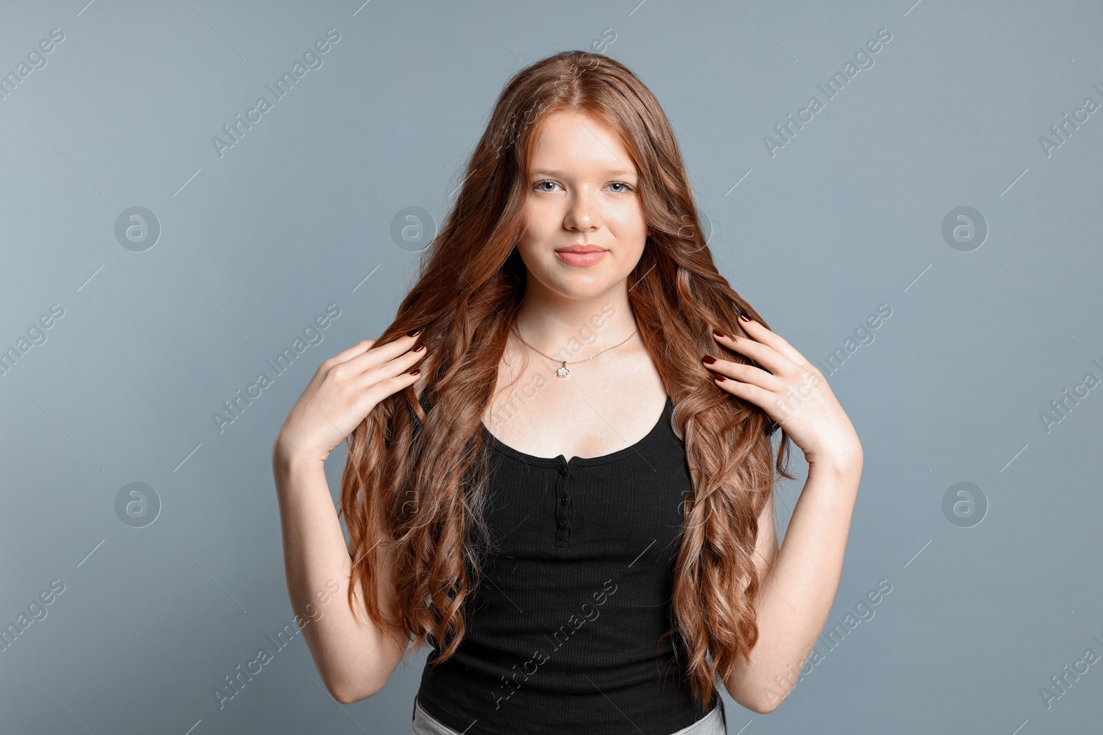 Photo of Teenage girl with healthy long hair on light grey background