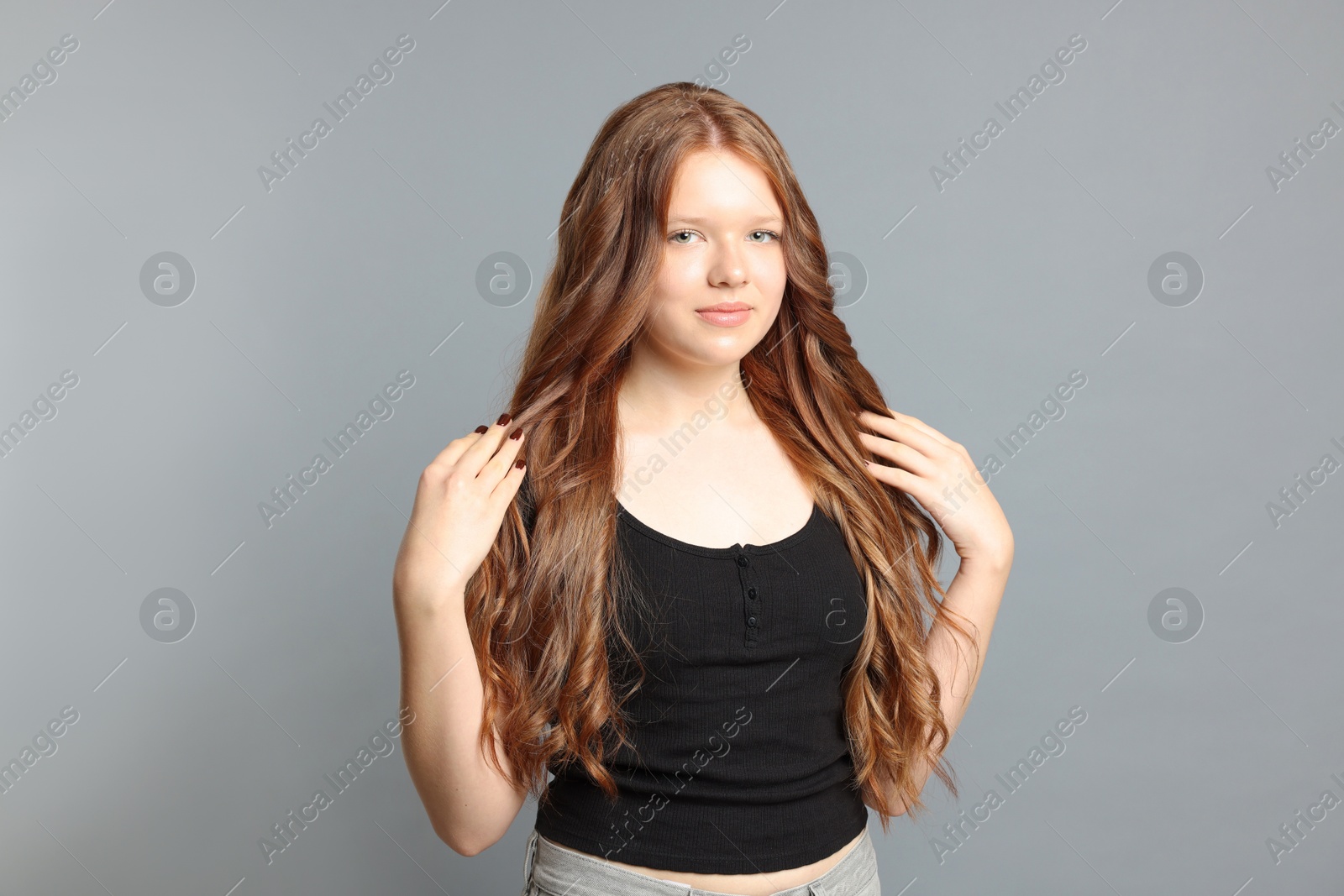 Photo of Teenage girl with healthy long hair on light grey background