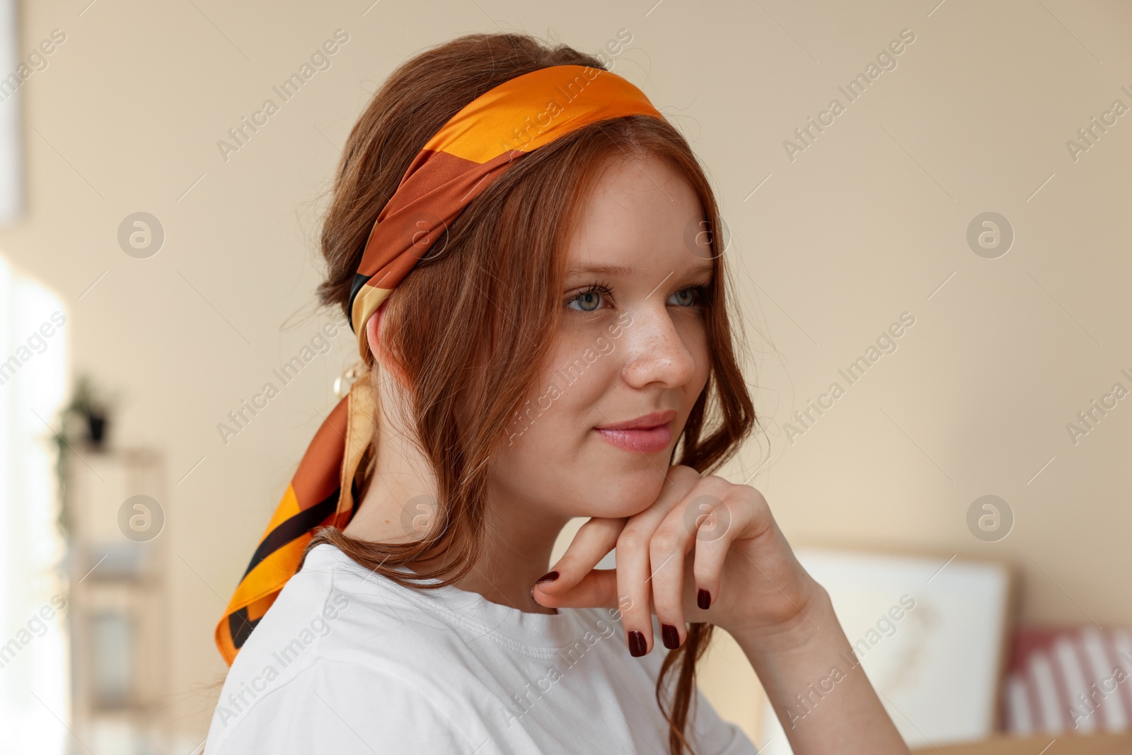 Photo of Red-haired teenage girl with stylish bandana indoors