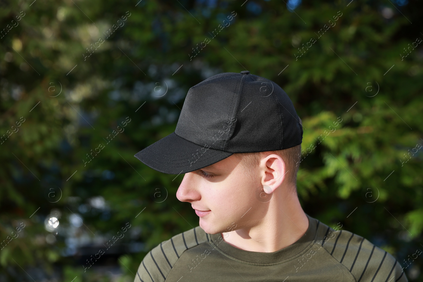 Photo of Man in stylish baseball cap outdoors. Mockup for design