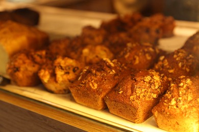 Photo of Delicious sweet pastries on display in cafe, closeup