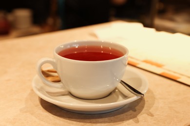 Photo of Cup of hot tea on table in cafe