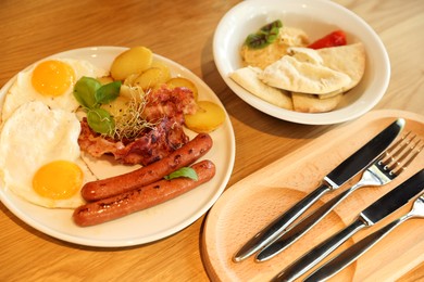 Photo of Delicious breakfast served on wooden table in restaurant, closeup