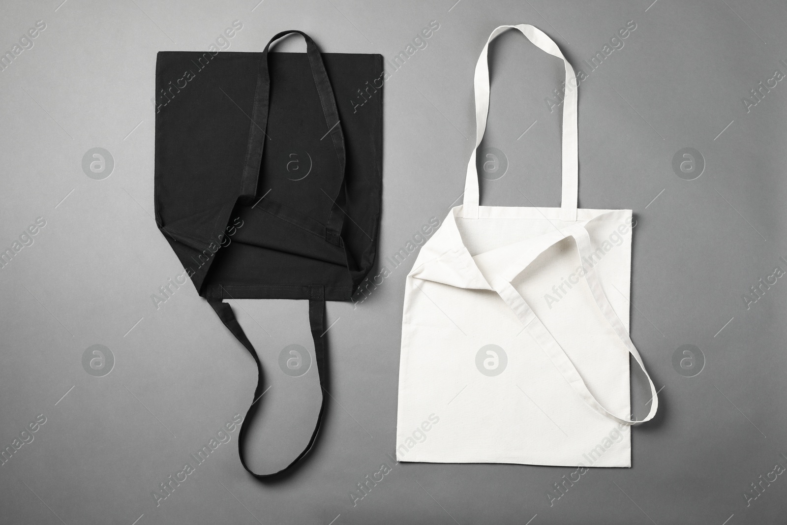 Photo of Shopping bags on grey background, flat lay. Mockup for design