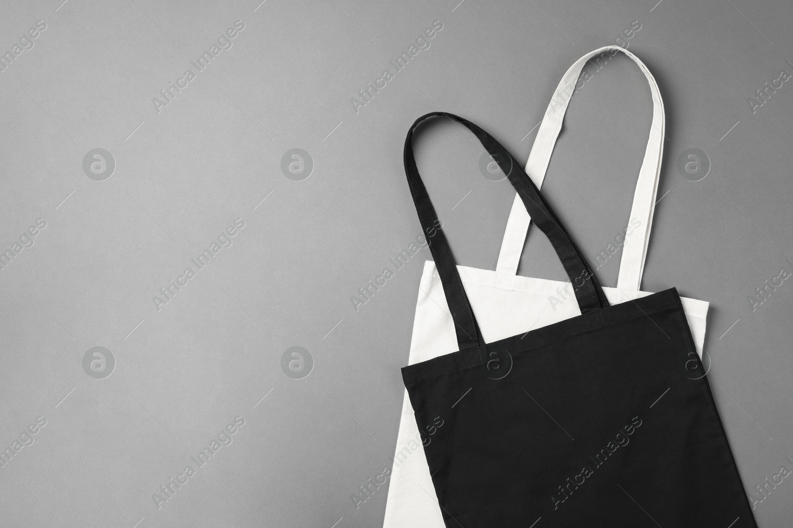 Photo of Shopping bags and space for text on grey background, top view. Mockup for design