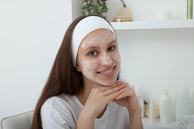 Photo of Teenage girl with cream on her face at home. Acne treatment