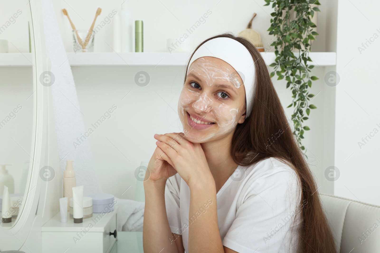 Photo of Teenage girl with cream on her face at home. Acne treatment