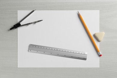 Photo of Ruler, paper, compass, eraser and pencil on white wooden table, flat lay. Space for text