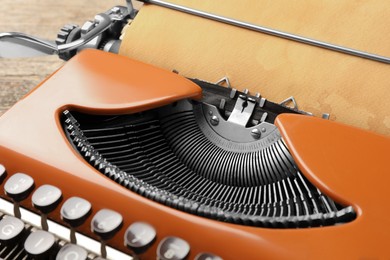 Photo of Vintage typewriter with sheet of parchment paper on table, closeup