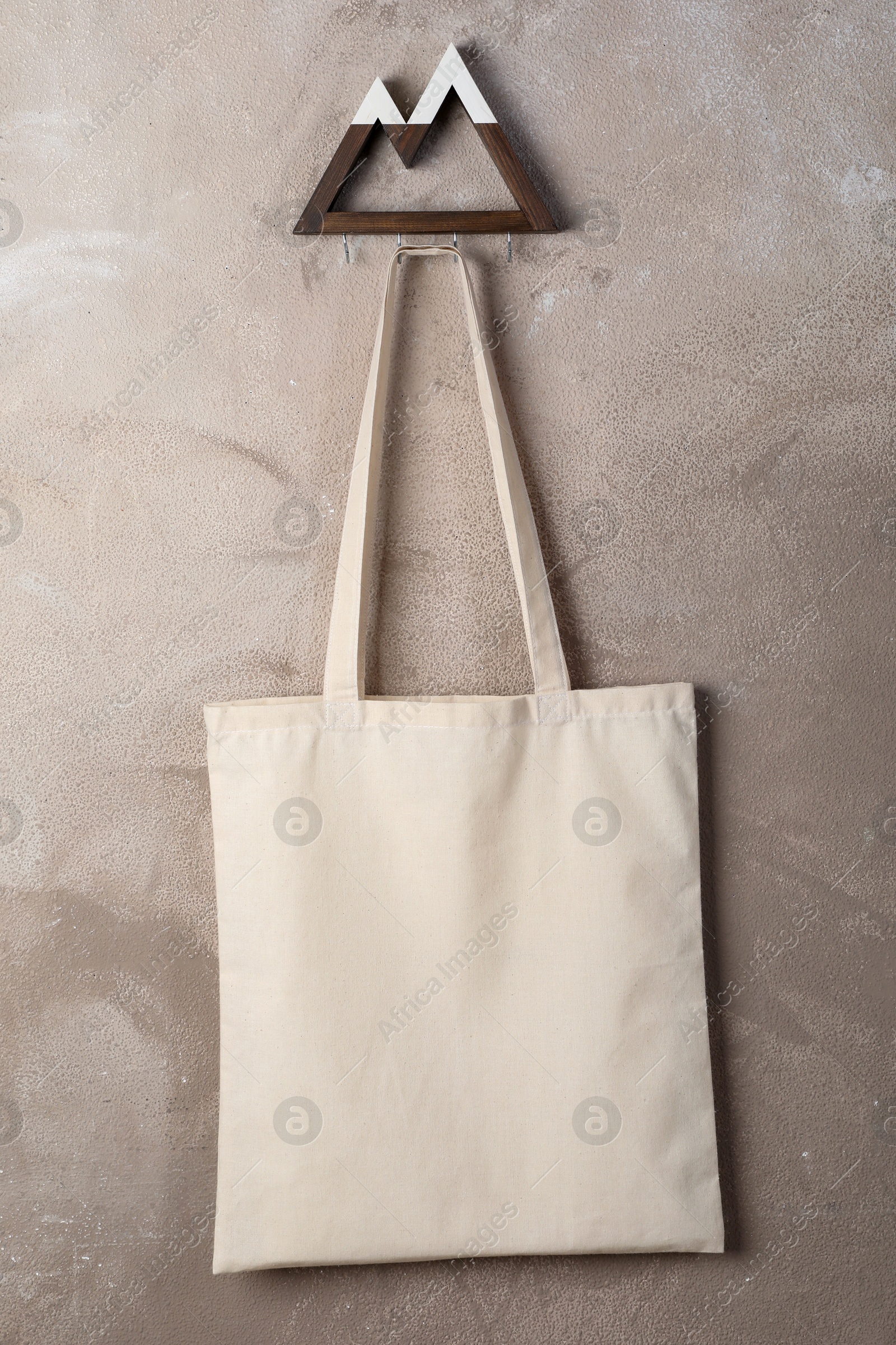 Photo of Eco bag hanging on grey wall. Mockup for design