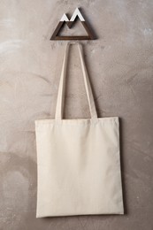 Photo of Eco bag hanging on grey wall. Mockup for design