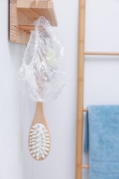 Photo of Shower cap and brush on rack indoors