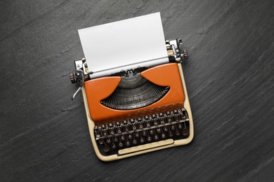 Photo of Vintage typewriter with sheet of paper on black background, top view