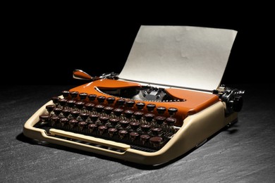 Photo of Vintage typewriter with sheet of paper on black background