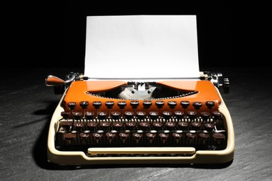 Photo of Vintage typewriter with sheet of paper on black background