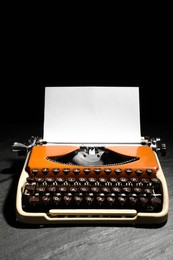 Photo of Vintage typewriter with sheet of paper on black background