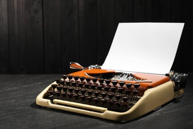 Photo of Vintage typewriter with sheet of paper on black background. Space for text
