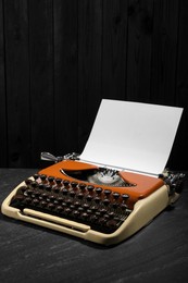Photo of Vintage typewriter with sheet of paper on black background