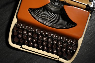 Photo of Vintage typewriter with parchment paper on black background, top view