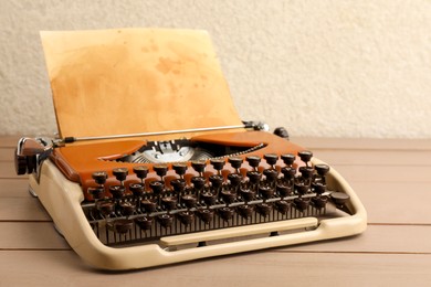 Photo of Vintage typewriter with parchment paper on wooden table
