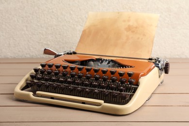 Photo of Vintage typewriter with parchment paper on wooden table