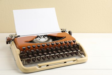 Vintage typewriter with sheet of paper on white wooden table