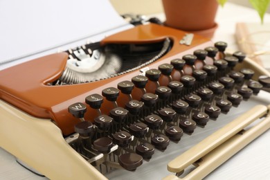 Photo of Vintage typewriter with sheet of paper on white table, closeup