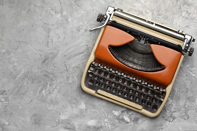Photo of Vintage typewriter on grey background, top view. Space for text