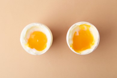 Photo of Soft boiled eggs in cups on beige background, top view