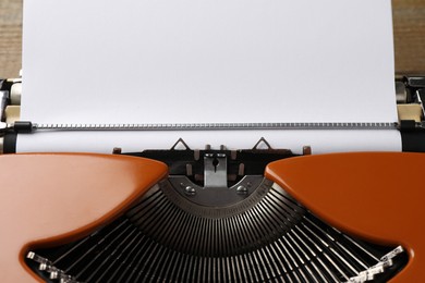 Photo of Vintage typewriter with sheet of paper on table, closeup. Space for text
