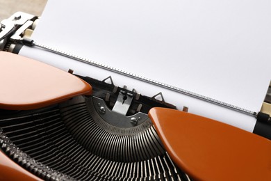 Photo of Vintage typewriter with sheet of paper on table, closeup. Space for text