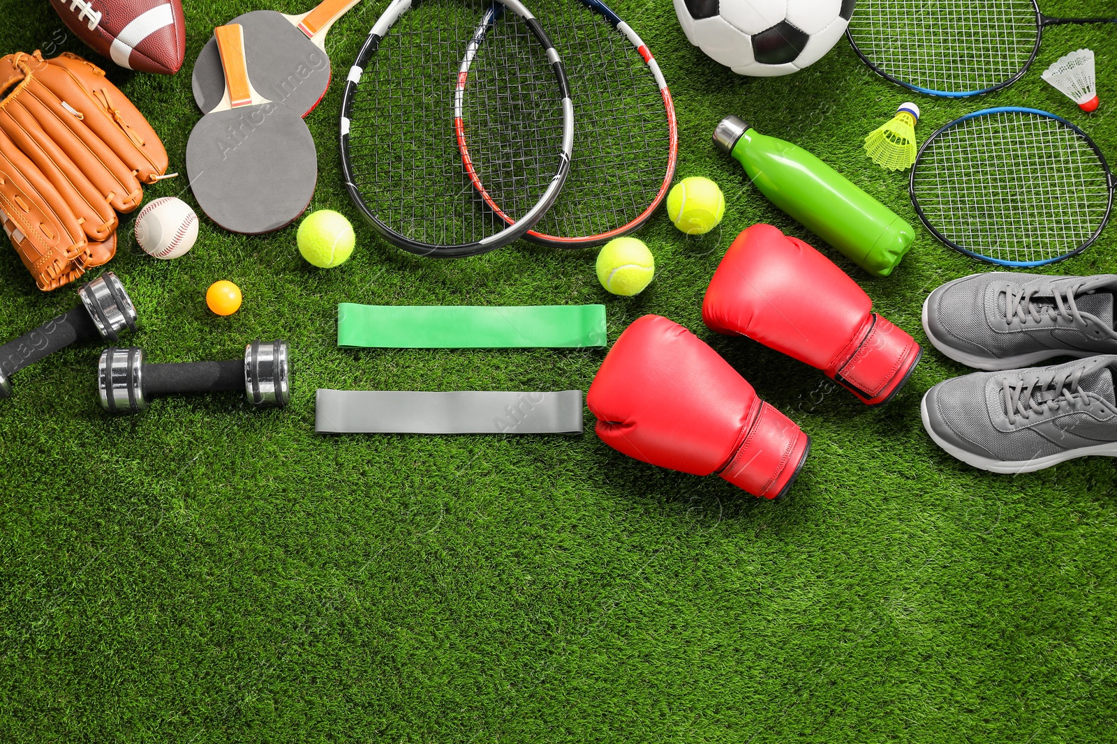 Photo of Different sport equipment on artificial grass, flat lay. Space for text