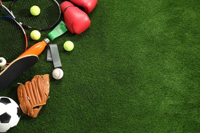 Photo of Different sport equipment on artificial grass, flat lay. Space for text