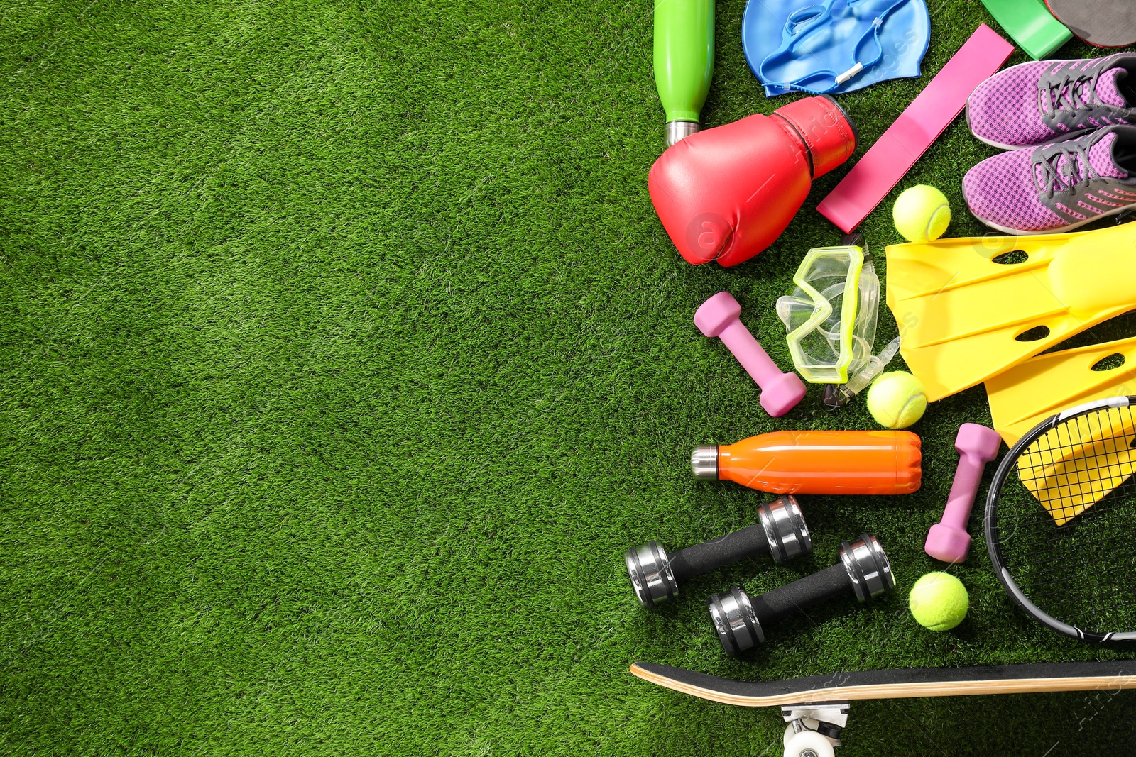 Photo of Different sport equipment on artificial grass, flat lay. Space for text