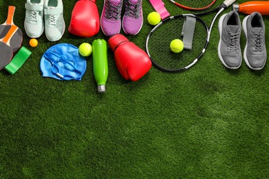 Photo of Different sport equipment on artificial grass, flat lay. Space for text