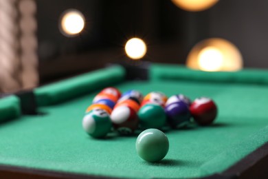 Photo of Billiard balls in triangle on green table indoors, closeup. Space for text