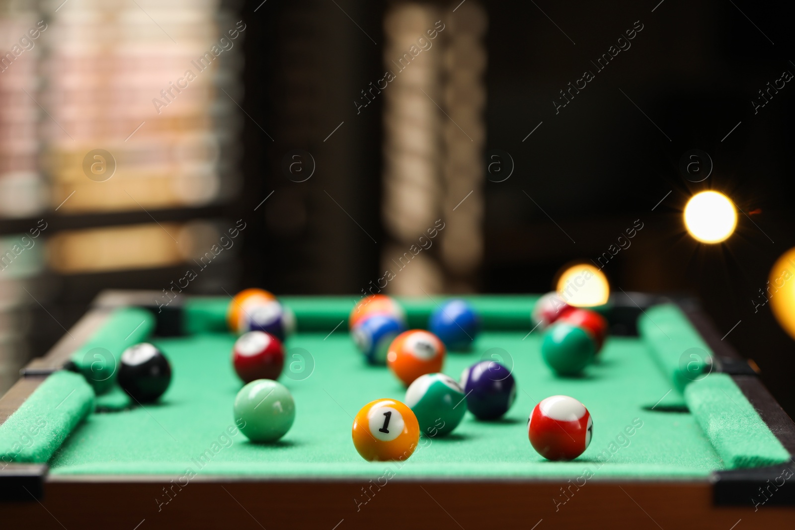 Photo of Many colorful billiard balls on green table indoors, closeup