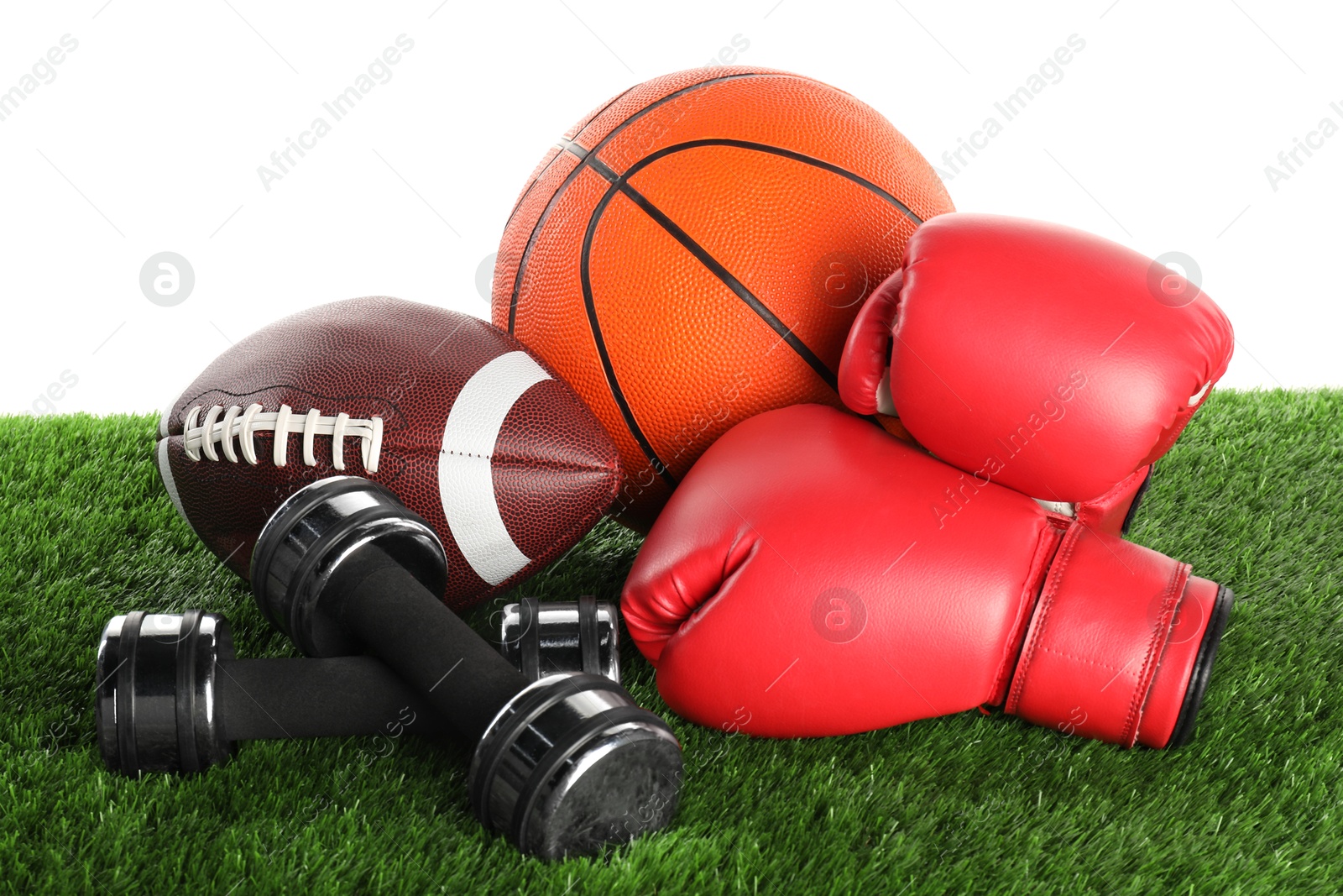 Photo of Different sport equipment on artificial grass isolated on white