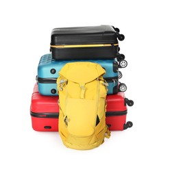 Photo of Stack of colorful suitcases and backpack isolated on white