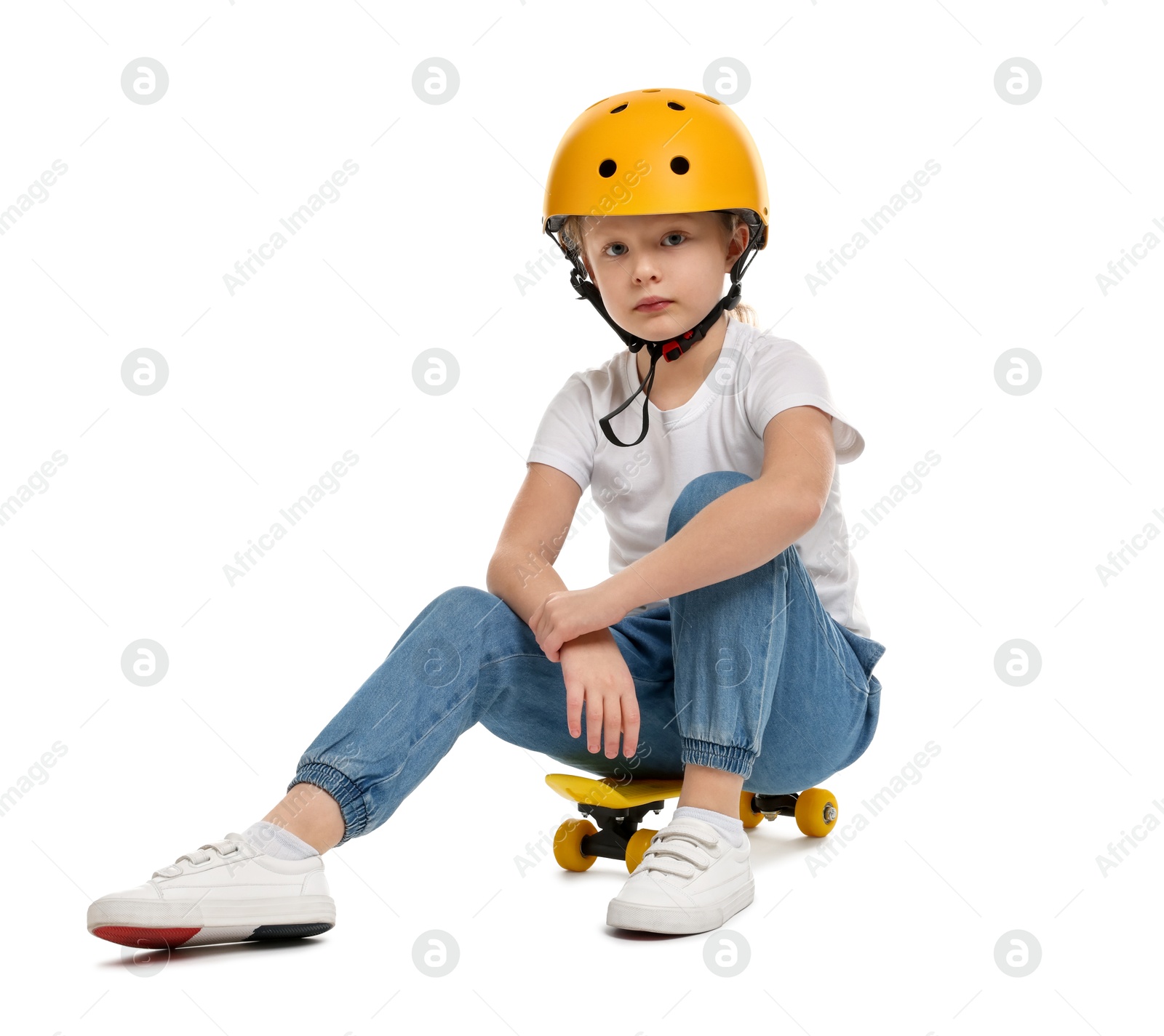 Photo of Little girl in helmet sitting on penny board against white background