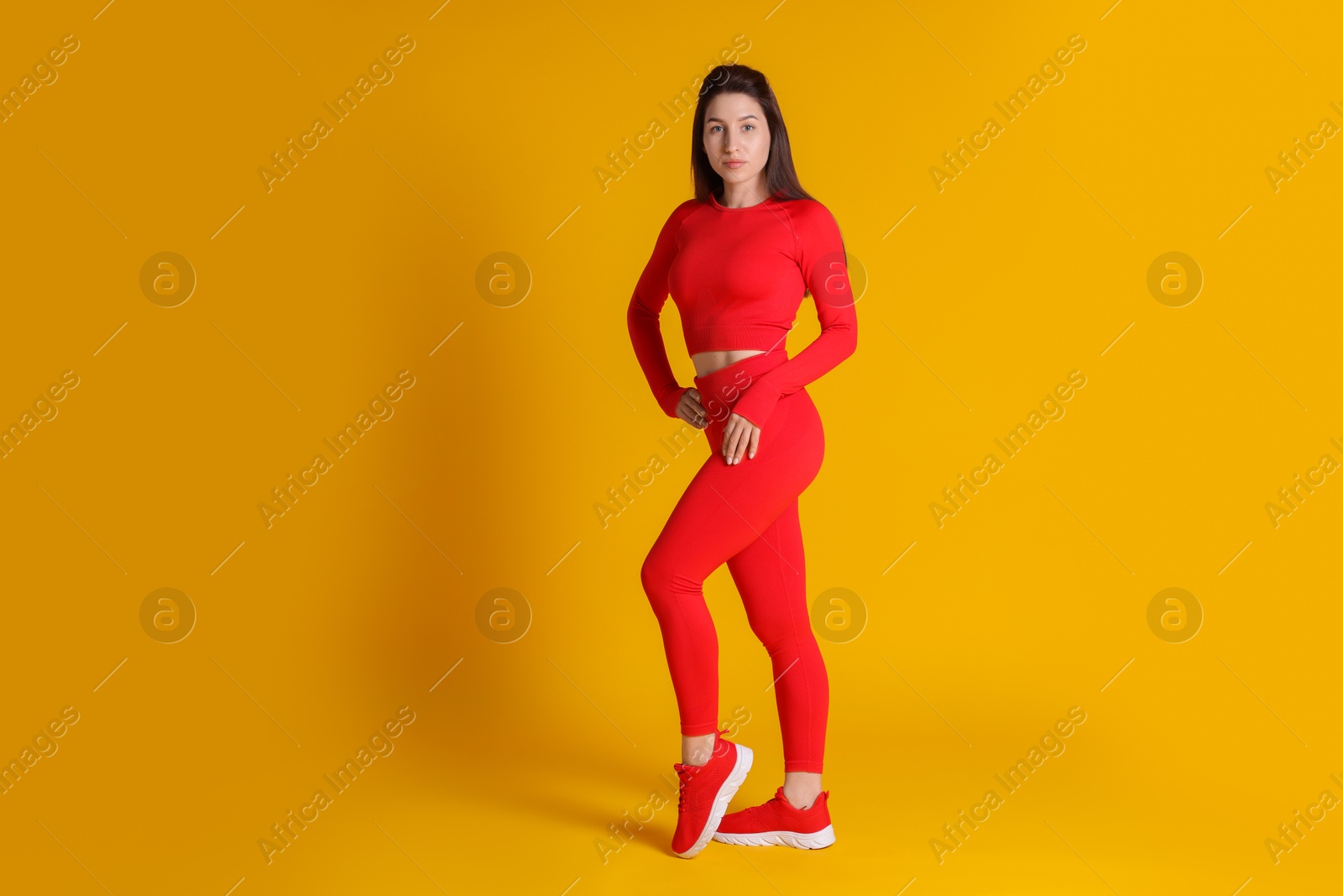 Photo of Portrait of woman in sportswear on orange background