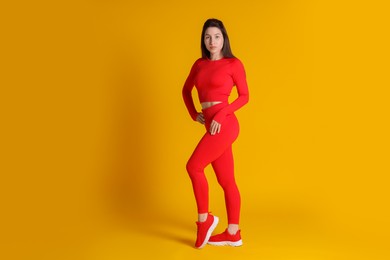 Photo of Portrait of woman in sportswear on orange background