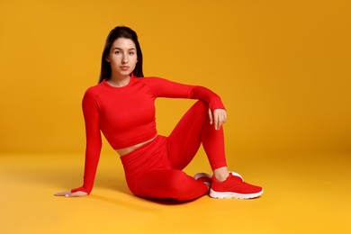 Photo of Portrait of woman in sportswear on orange background