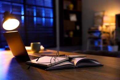 Photo of Workspace with laptop on wooden desk in home office, selective focus. Space for text