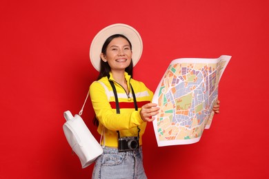 Photo of Happy traveller with map on red background