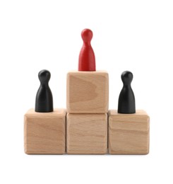 Photo of Human figures on wooden blocks, red one on top against white background. Competition concept