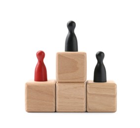 Photo of Human figures on wooden blocks, black one on top against white background. Competition concept