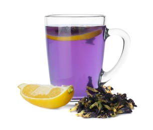 Photo of Delicious butterfly pea flower tea in glass mug, lemon and dry petals isolated on white