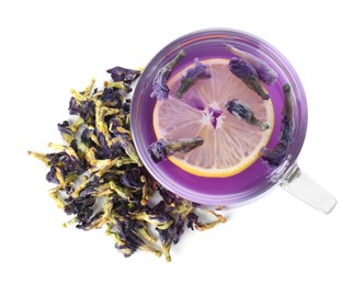 Photo of Delicious butterfly pea flower tea with lemon in glass cup and dry petals isolated on white, top view