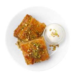 Photo of Tasty baklava with chopped nuts and scoop of ice cream isolated on white, top view